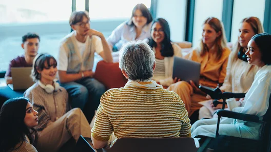 A group of diverse people sitting in a circle at a community gathering.
