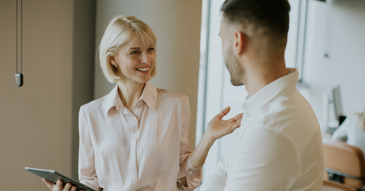Two colleagues engaged in active dialogue in an office setting