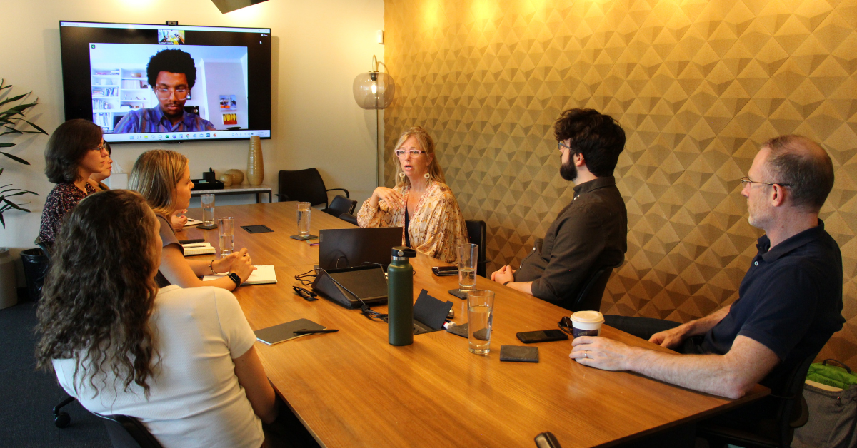A group of leaders exhibiting emotional intelligence in a workplace setting through active listening during a conversation with a colleague.